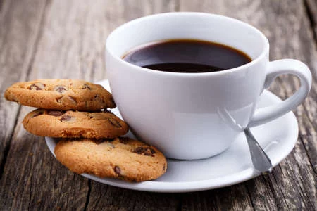 a-de-caf%C3%A9-con-galletas-en-una-mesa-de-madera-.webp