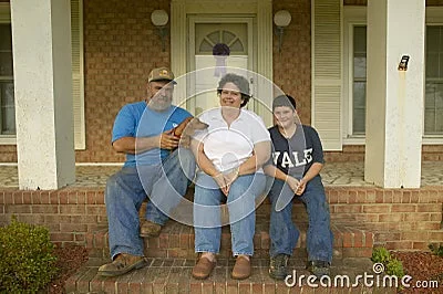 family-sitting-front-porch-house-23180241.webp